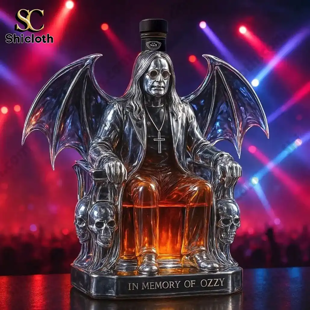 PREMIUM In Memory of Ozzy Osbourne Edition Whiskey Bottle 4 A silver statue-shaped whiskey bottle depicting a seated figure with bat wings and a black cap under concert lights.