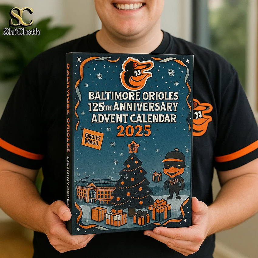 Fan in Orioles shirt holding the 2025 Baltimore Orioles 125th Anniversary advent calendar.