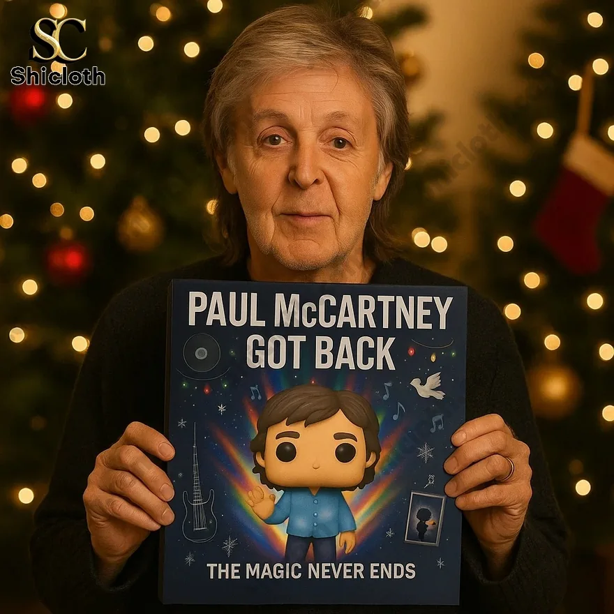 An older man holding a Paul McCartney Got Back advent calendar in front of a Christmas tree.