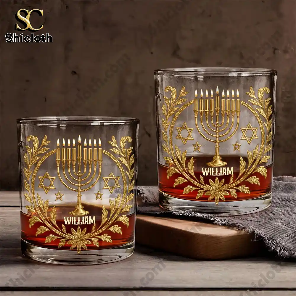 Two menorah whiskey glasses with the name William on a wooden surface.