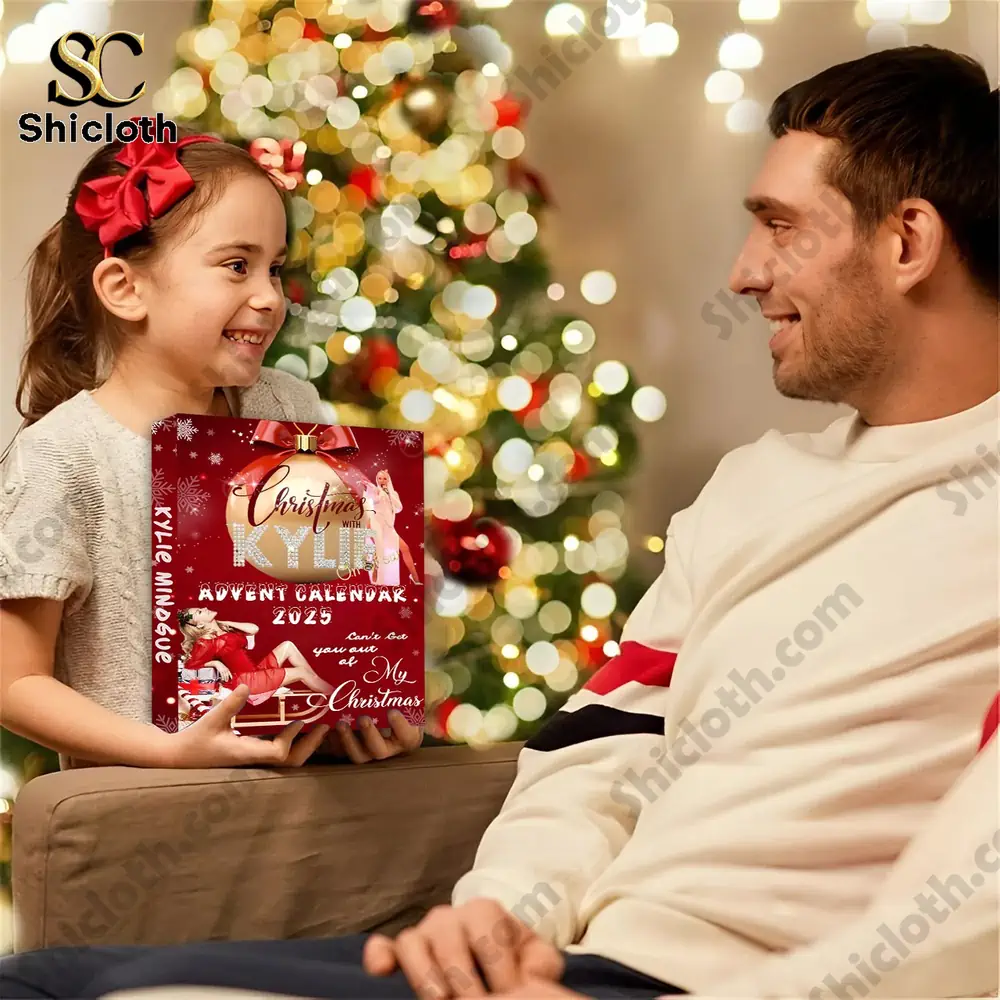 Kylie Minogue Premium Advent Calendar 2025 4 A young girl presents a Kylie Minogue Advent Calendar 2025 to her smiling father by a Christmas tree.