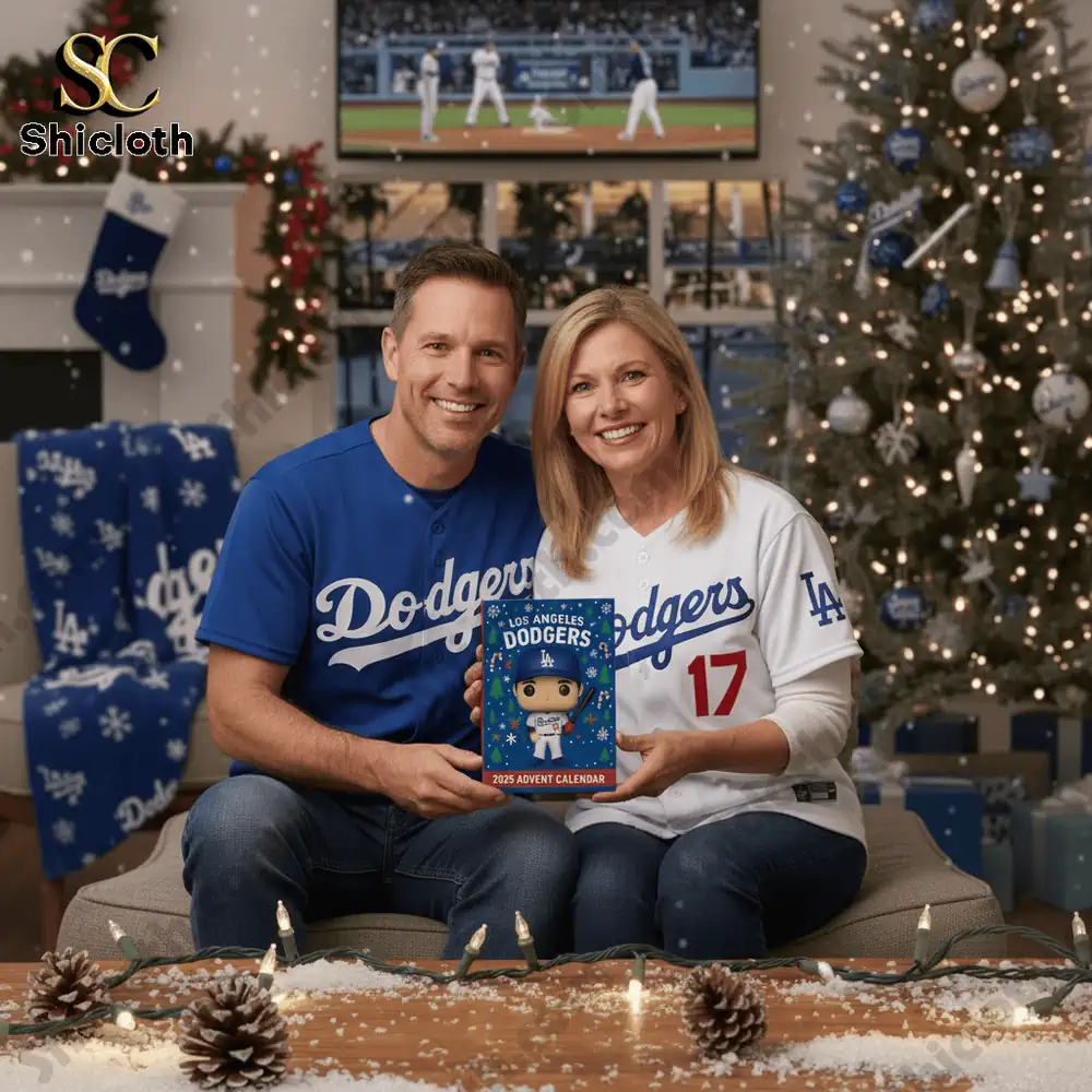 A couple wearing Dodgers jerseys holds a Los Angeles Dodgers Advent Calendar 2025 in a cozy Christmas living room!