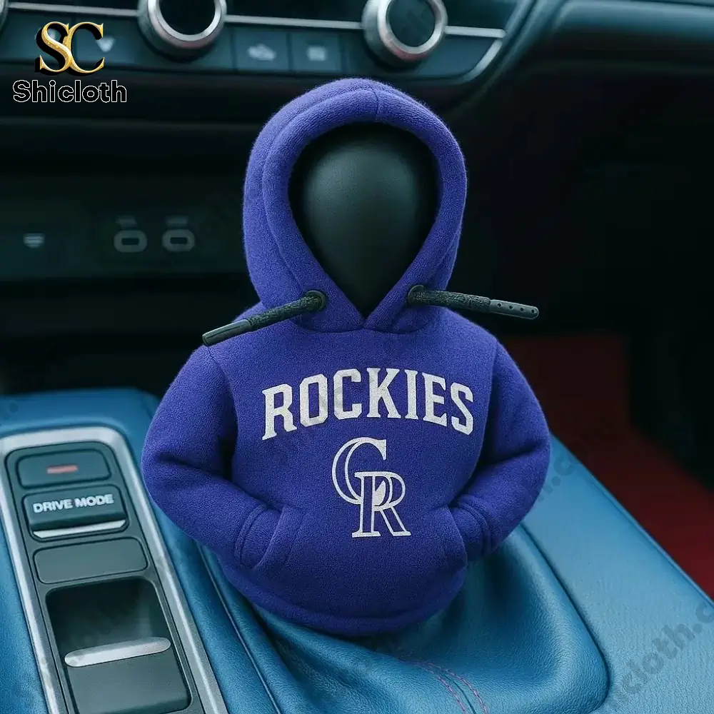 A car gear shift cover figure wearing a purple hoodie with the Rockies baseball team logo inside a car by Shicloth!