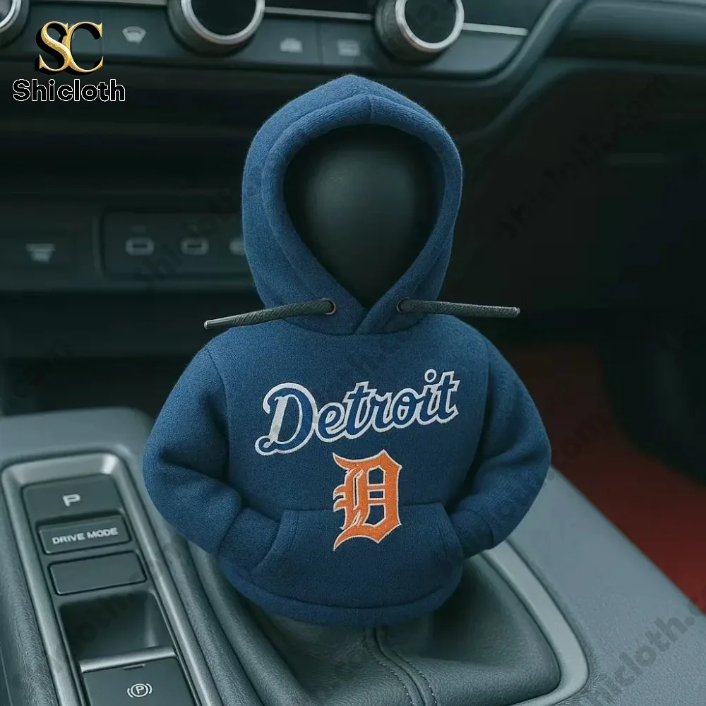 A car gear shift cover figure wearing a navy blue hoodie with the Detroit baseball team logo inside a vehicle by Shicloth!