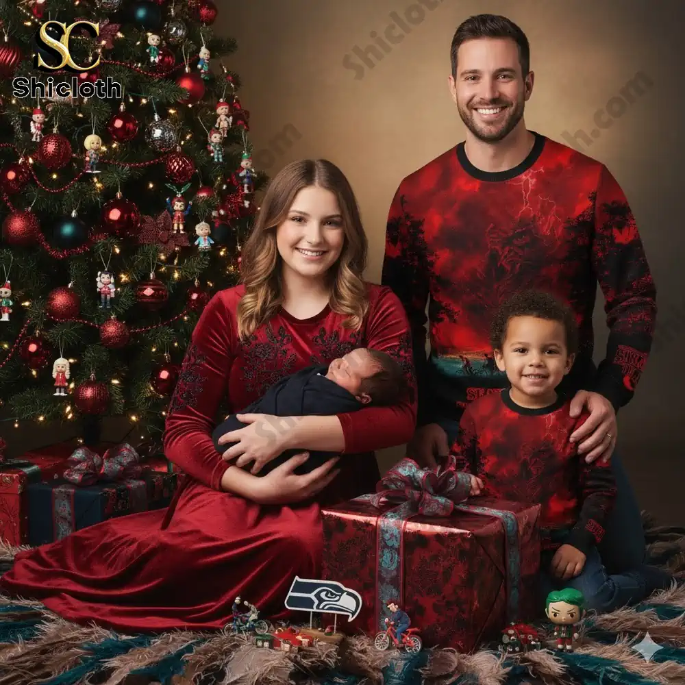 A family sits by a decorated Christmas tree wearing matching Seattle Seahawks and Stranger Things themed sweaters.