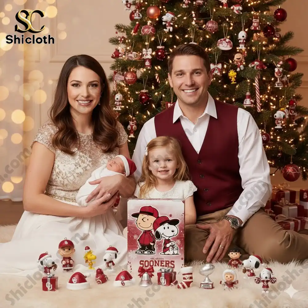 A family sits by a Christmas tree with Oklahoma Sooners themed Snoopy advent calendar and ornaments.