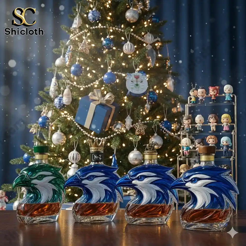 Four eagle shaped glass liquor bottles displayed in front of a decorated Christmas tree.
