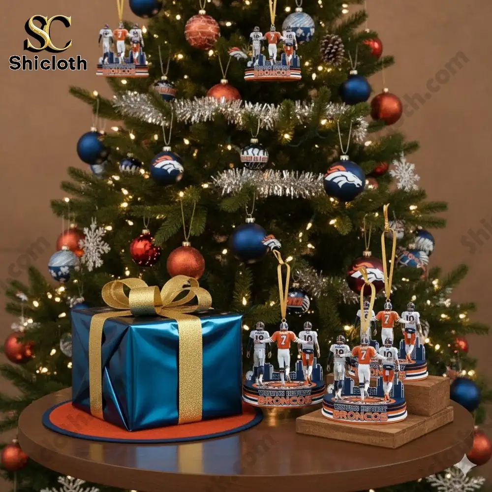 Christmas tree decorated with blue and orange team themed ornaments with a gift box in front!