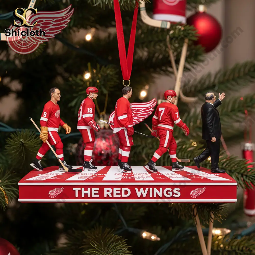 A Christmas tree adorned with Detroit Red Wings-themed ornaments and a red gift box on a table beneath.