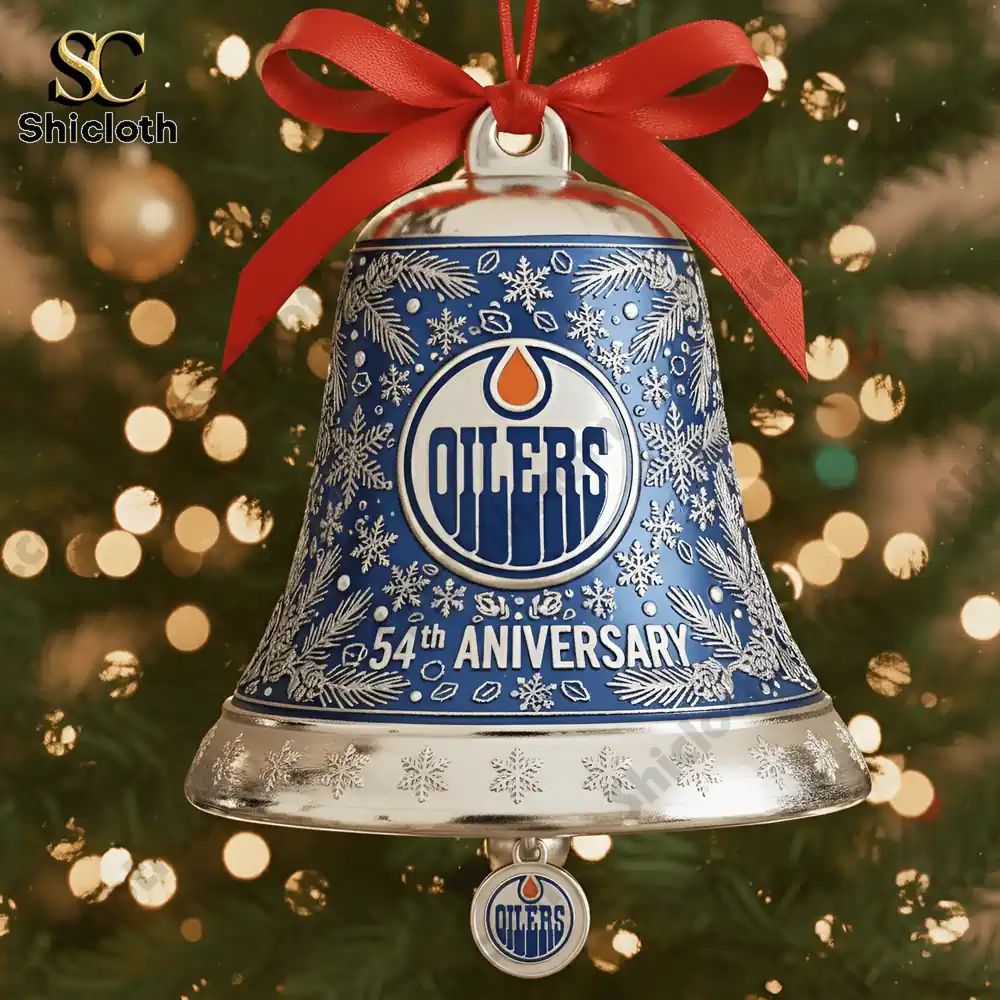 Close up of an Edmonton Oilers 54th anniversary blue Christmas bell ornament with snowflake design hanging on a tree.
