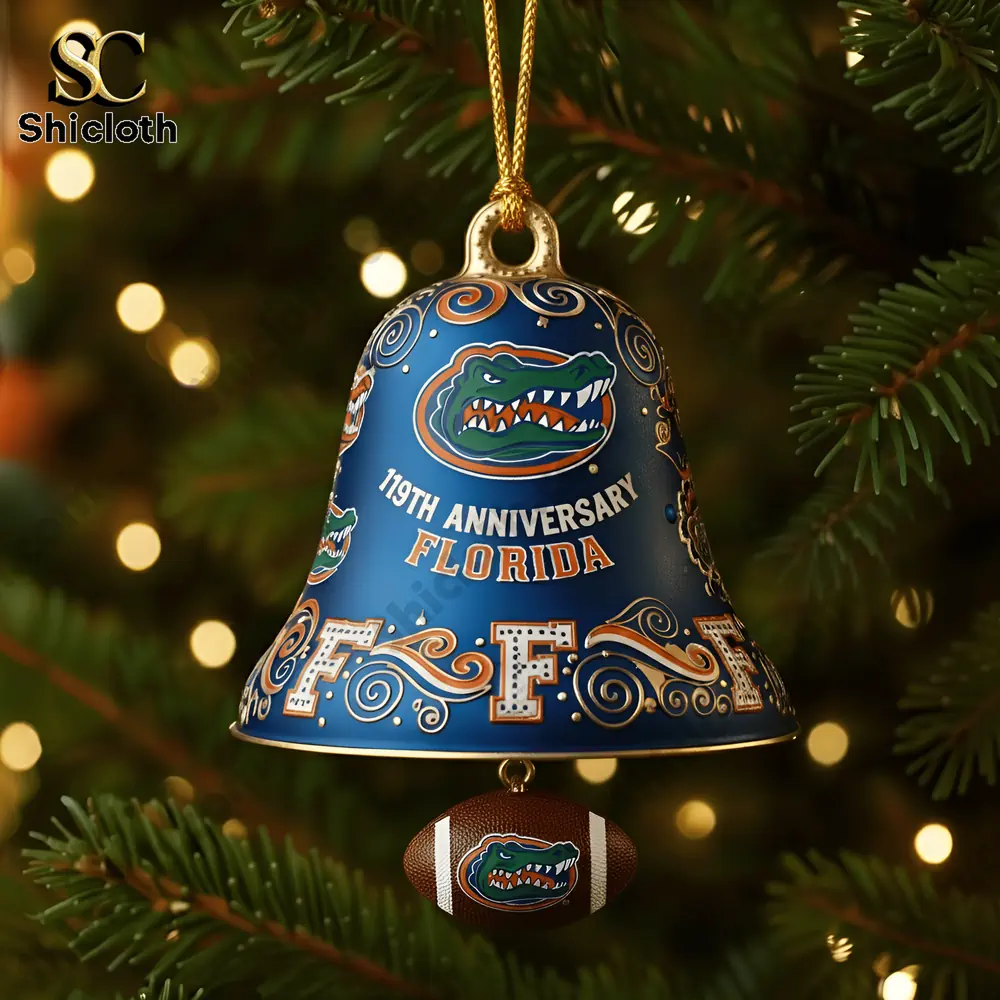A blue Florida Gators Christmas bell ornament hanging on a tree with warm lights in the background!
