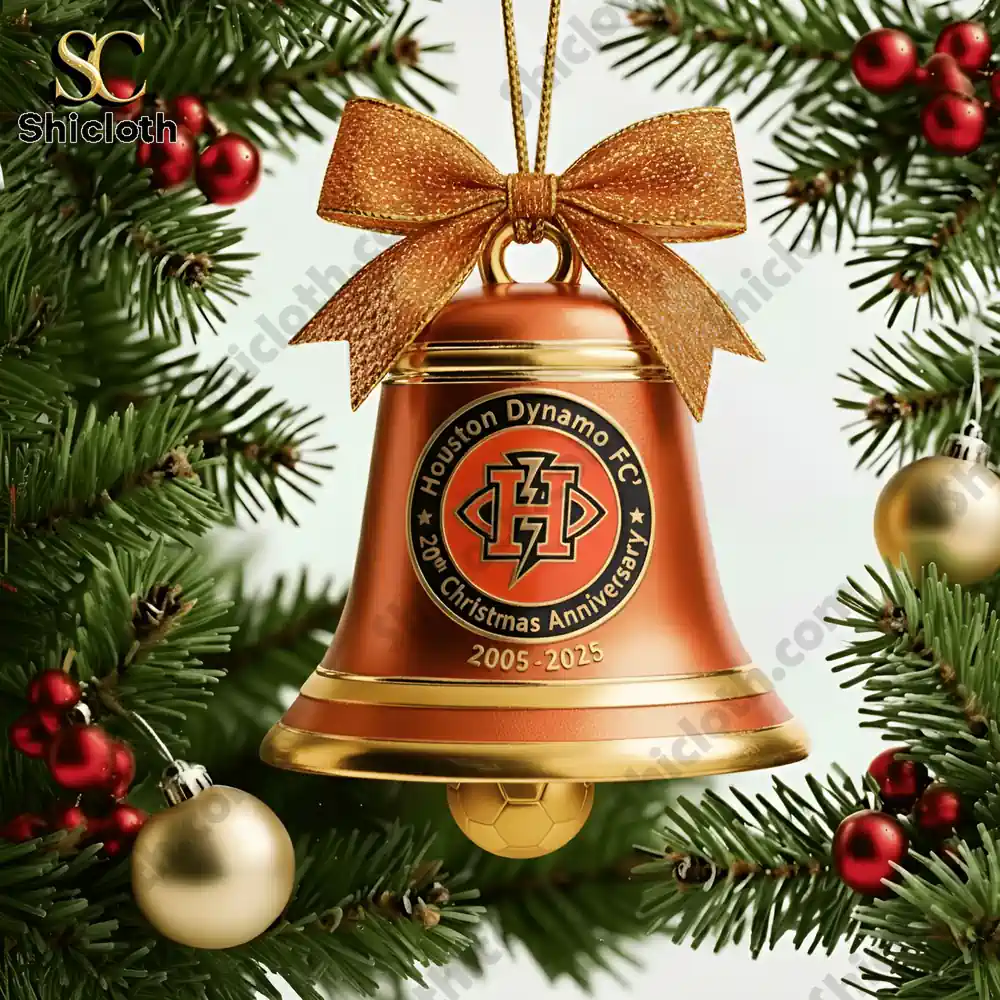 A close up of an orange Houston Dynamo FC 20th Anniversary Christmas bell ornament with a golden bow and soccer ball charm!