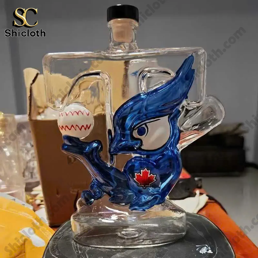 Glass bottle shaped with a blue bird holding a baseball featuring a red maple leaf emblem.