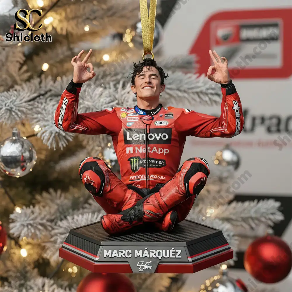 A close-up of a Marc Marquez MotoGP rider figure ornament hanging from a Christmas tree with a white and silver background.