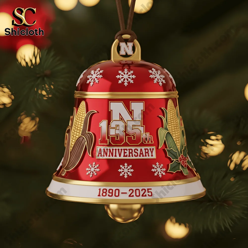 Close up of a red and gold Nebraska Cornhuskers 135th anniversary Christmas bell ornament with corn motifs and the date 1890 to 2025.
