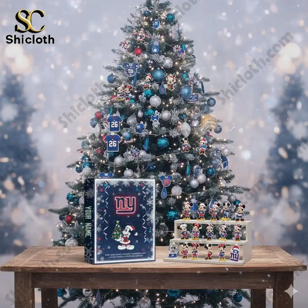 A Christmas tree decorated with New York Giants ornaments beside a Shicloth Advent Calendar displayed on a wooden table.