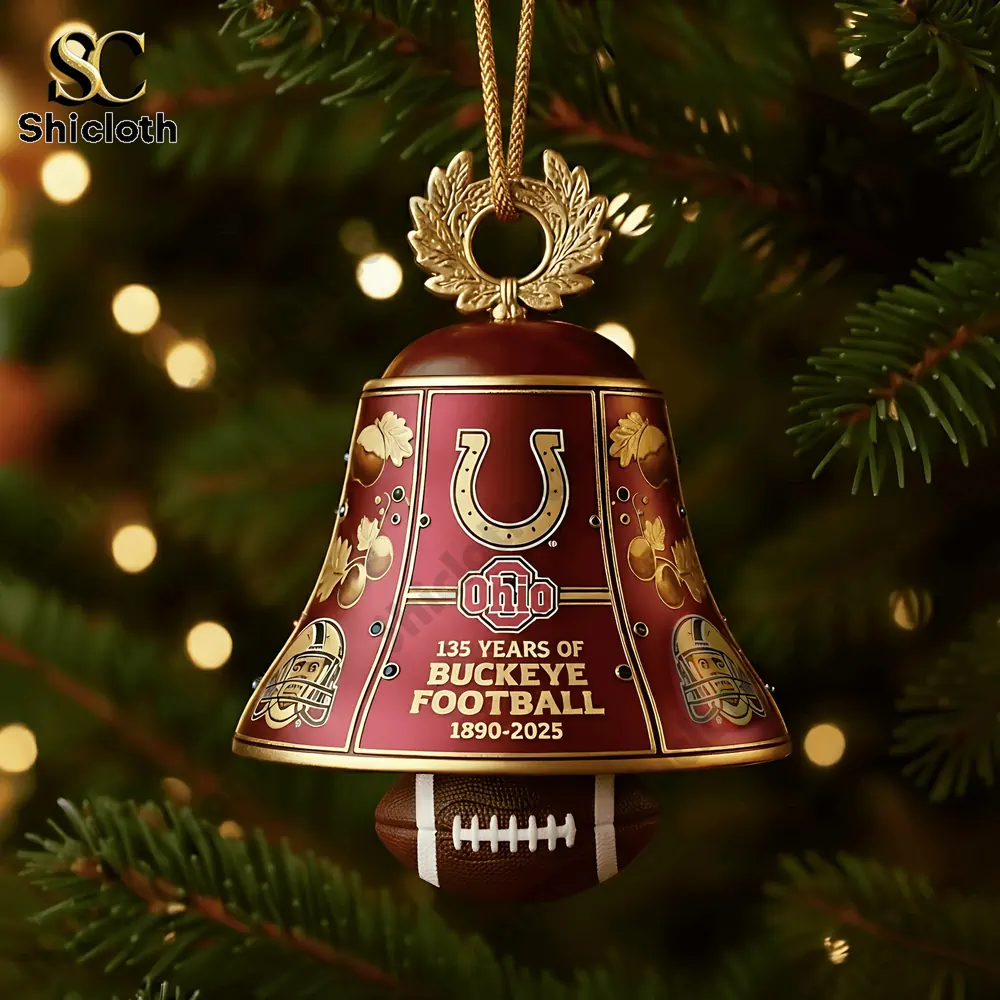 A close up of an Ohio State Buckeyes 135th anniversary Christmas bell ornament hanging on a tree branch.