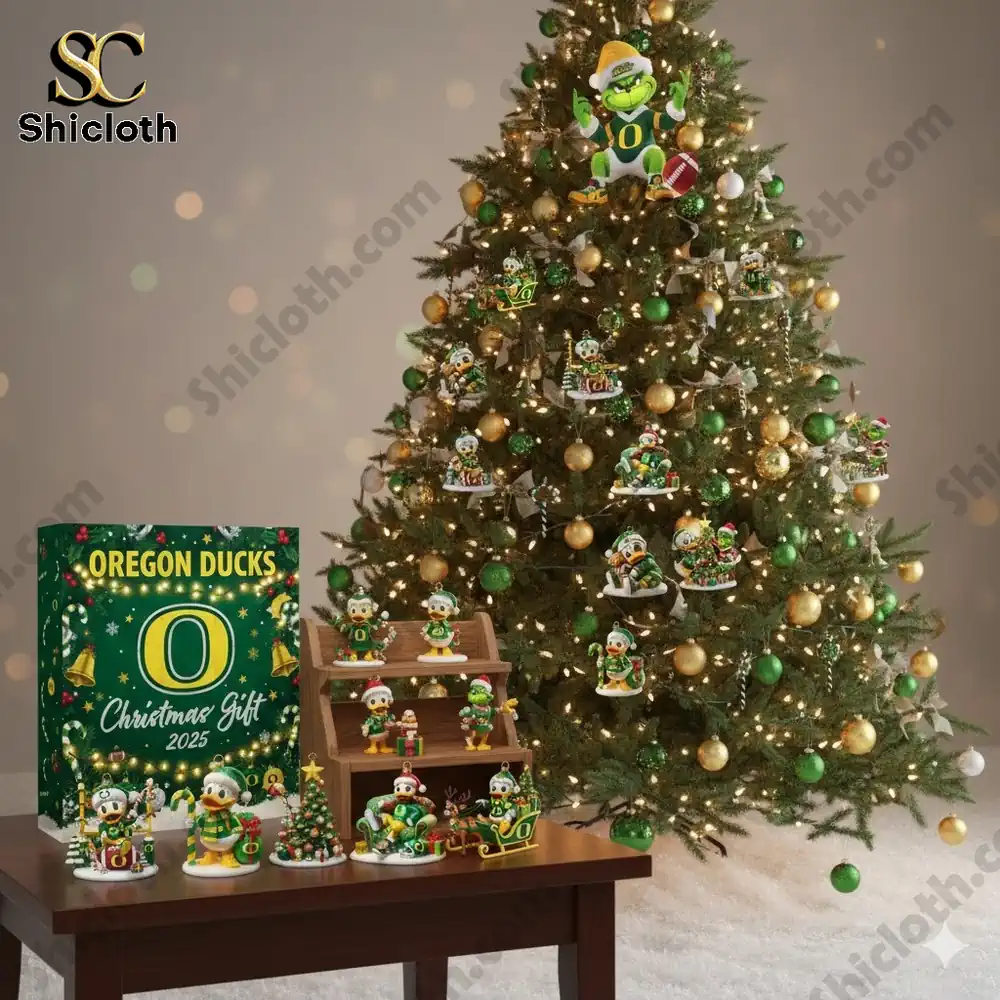 Christmas tree decorated with Oregon Ducks themed ornaments and a boxed set displayed on a table.