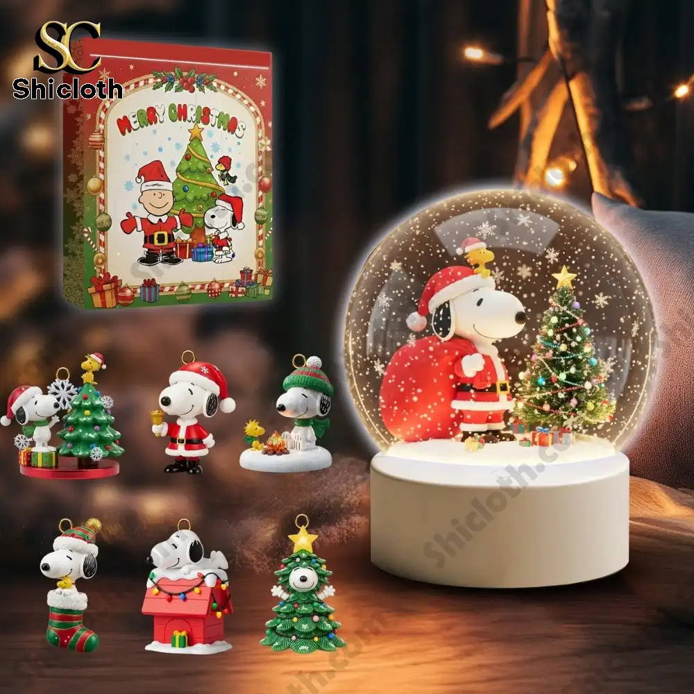 Peanut And Snoopy Christmas 2025 Snowball Led Light And Ornament Set 8 Snoopy Christmas ornaments and a Shicloth holiday box beside a glowing snow globe.