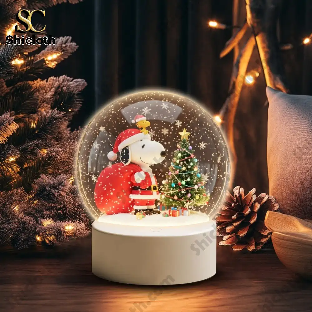 Peanut And Snoopy Christmas 2025 Snowball Led Light And Ornament Set 9 Snoopy snow globe with a Christmas tree glowing in a warm room.