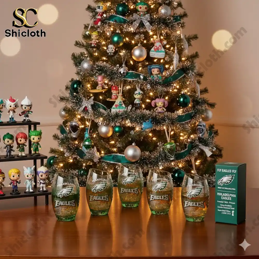 Christmas tree with ornaments and collectible figures beside several green Philadelphia Eagles glasses on a table.