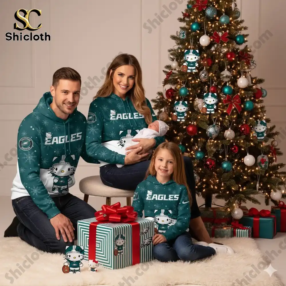 A family wearing Hello Kitty Philadelphia Eagles hoodies, posing with gifts by a Christmas tree.