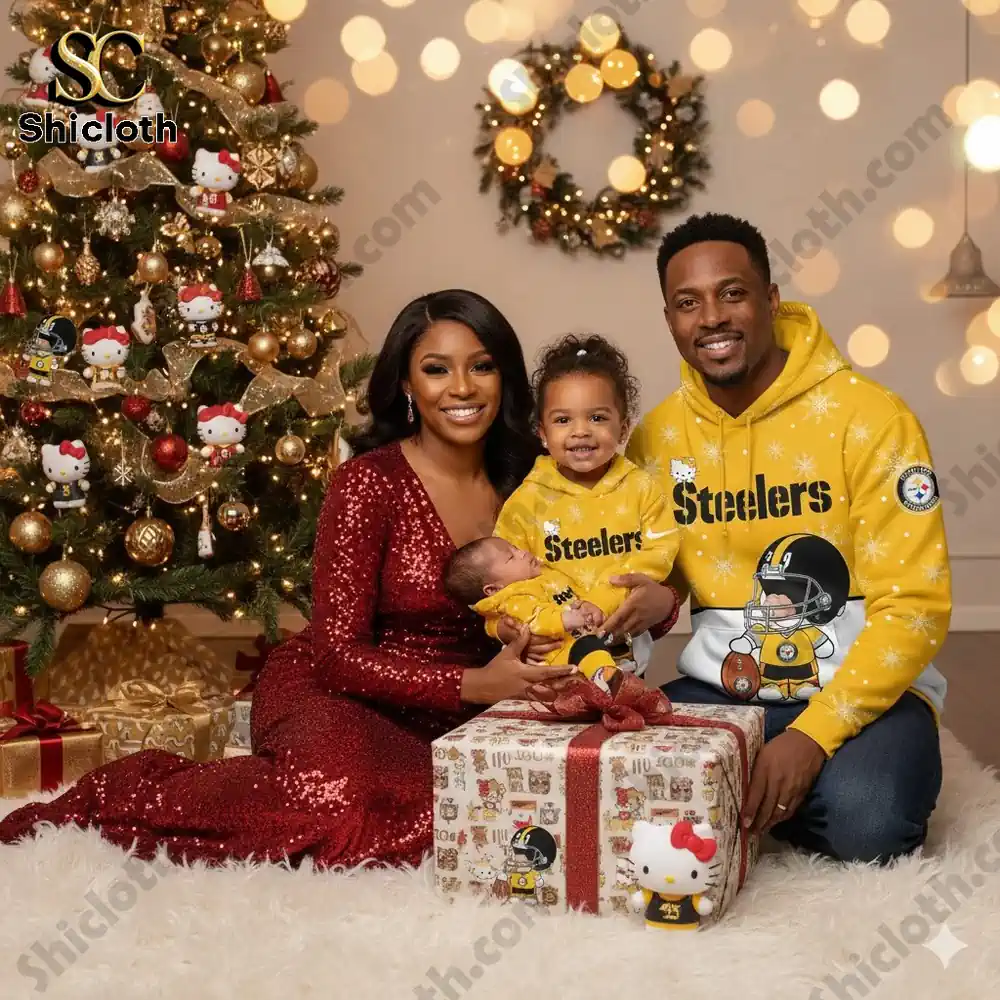 A family in Pittsburgh Steelers attire celebrates Christmas in front of a decorated tree, with the mother holding a baby and the father with a toddler.