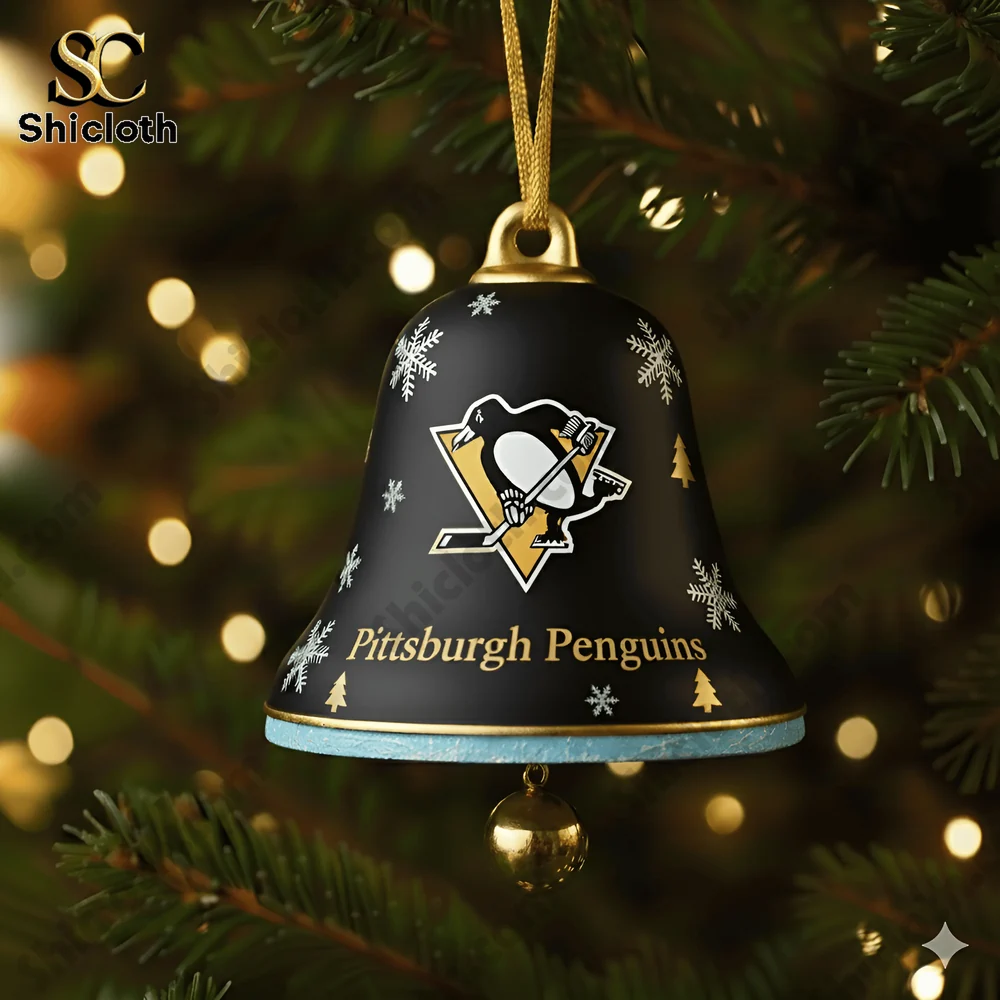 A close up of a Pittsburgh Penguins 58th anniversary Christmas bell ornament hanging on a tree.