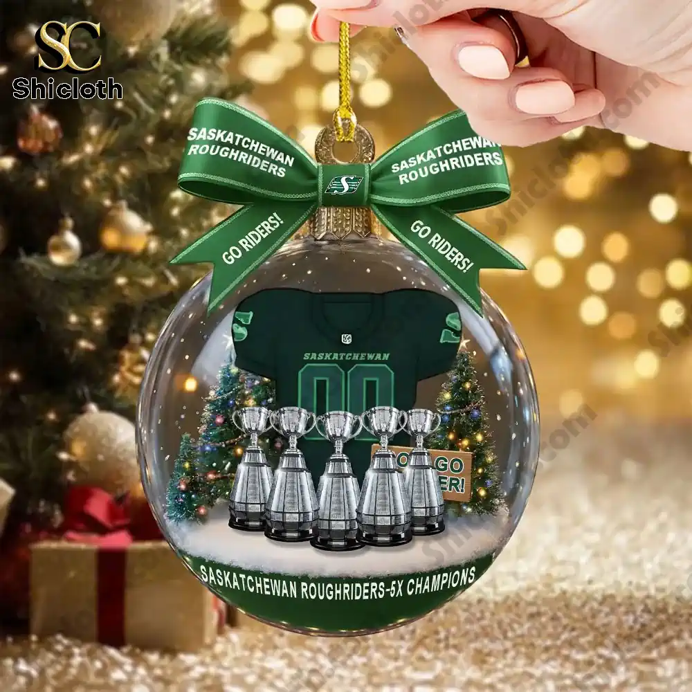 Hand holding a clear ornament with a Saskatchewan Roughriders jersey and trophies.