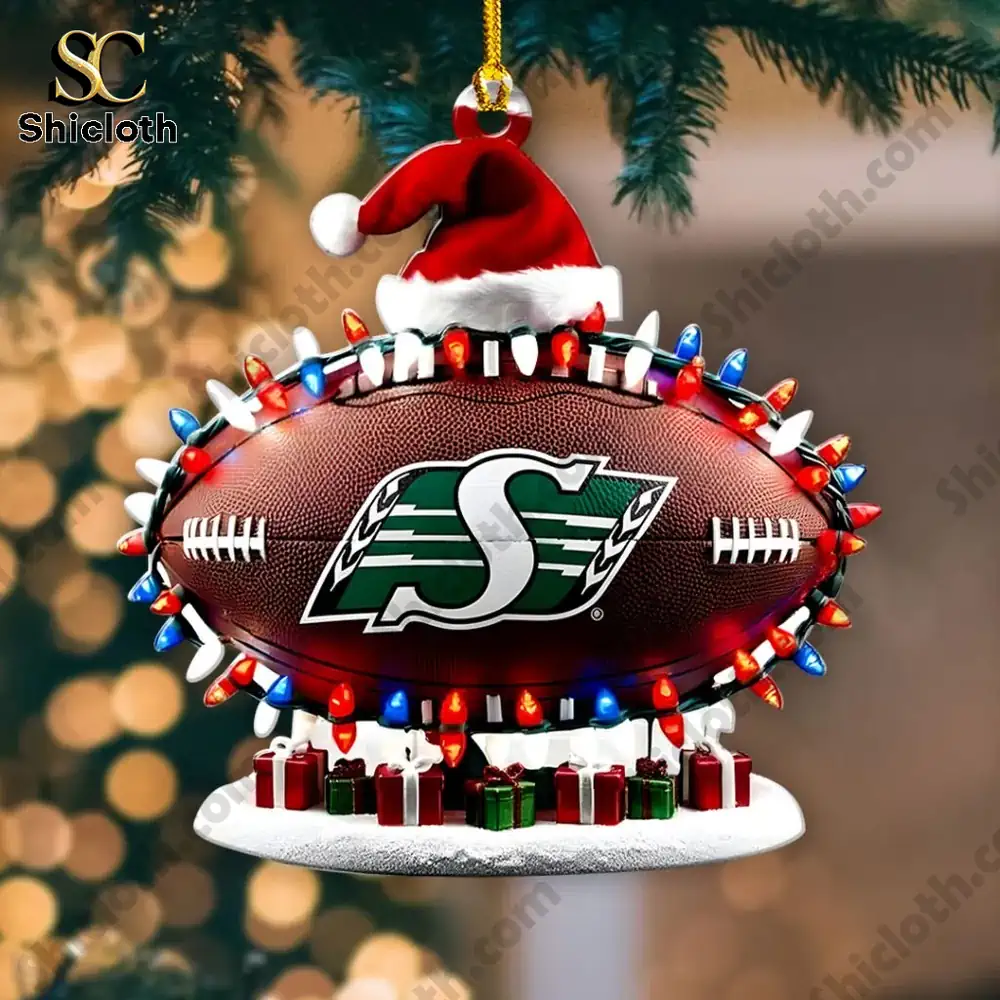 Saskatchewan Roughriders Christmas Rugby Acrylic Ornament 3 Saskatchewan Roughriders football ornament glowing against warm holiday lights.