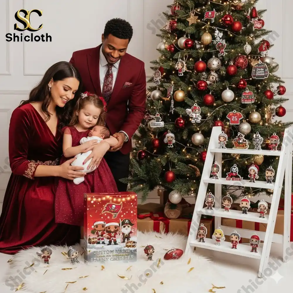 A smiling family in red outfits sitting by a Christmas tree with a Tampa Bay Buccaneers Advent Calendar and collectible figures on display!