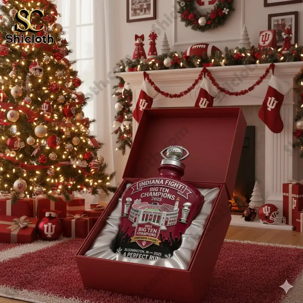 A Christmas setting with an Indiana Hoosiers Big Ten Champions whiskey bottle gift box in front of a decorated Christmas tree.