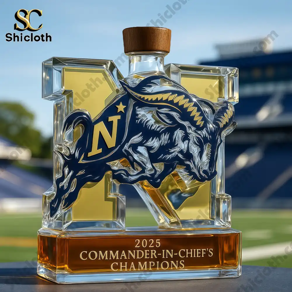 2025 Navy Commander-in-chief’s Champions Whiskey Bottle 3 A Navy trophy whiskey bottle with a wooden cap placed on a table in front of a football stadium.