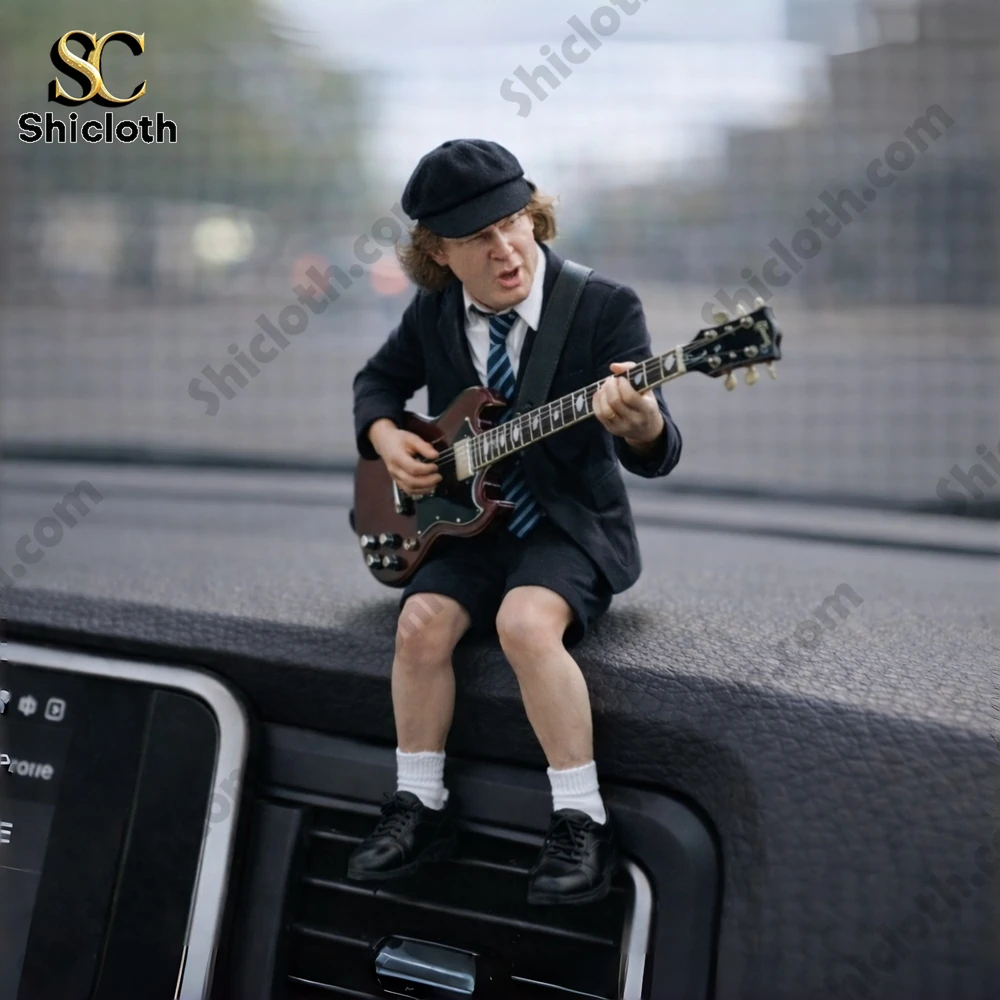 Mini guitarist figure sitting on a car dashboard playing electric guitar!