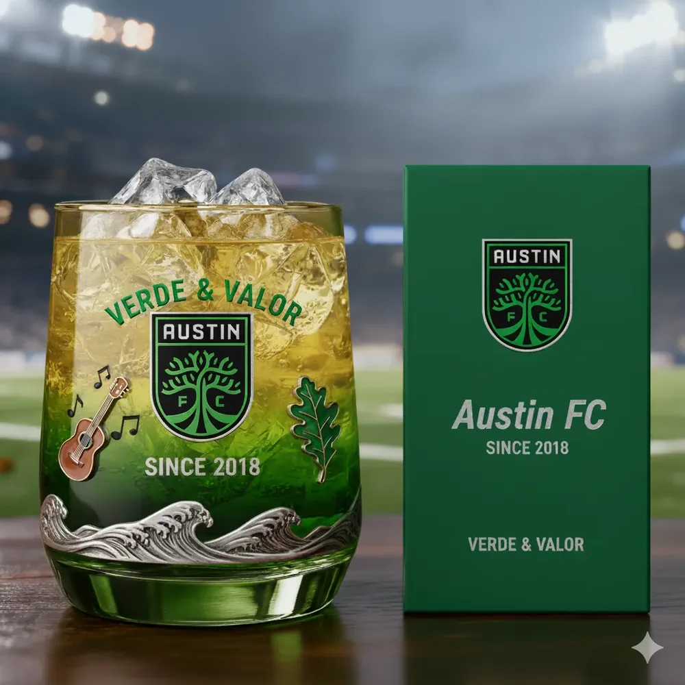 Austin FC Christmas Whiskey Glass 3 An Austin FC glass with ice beside a branded box in front of a stadium background.