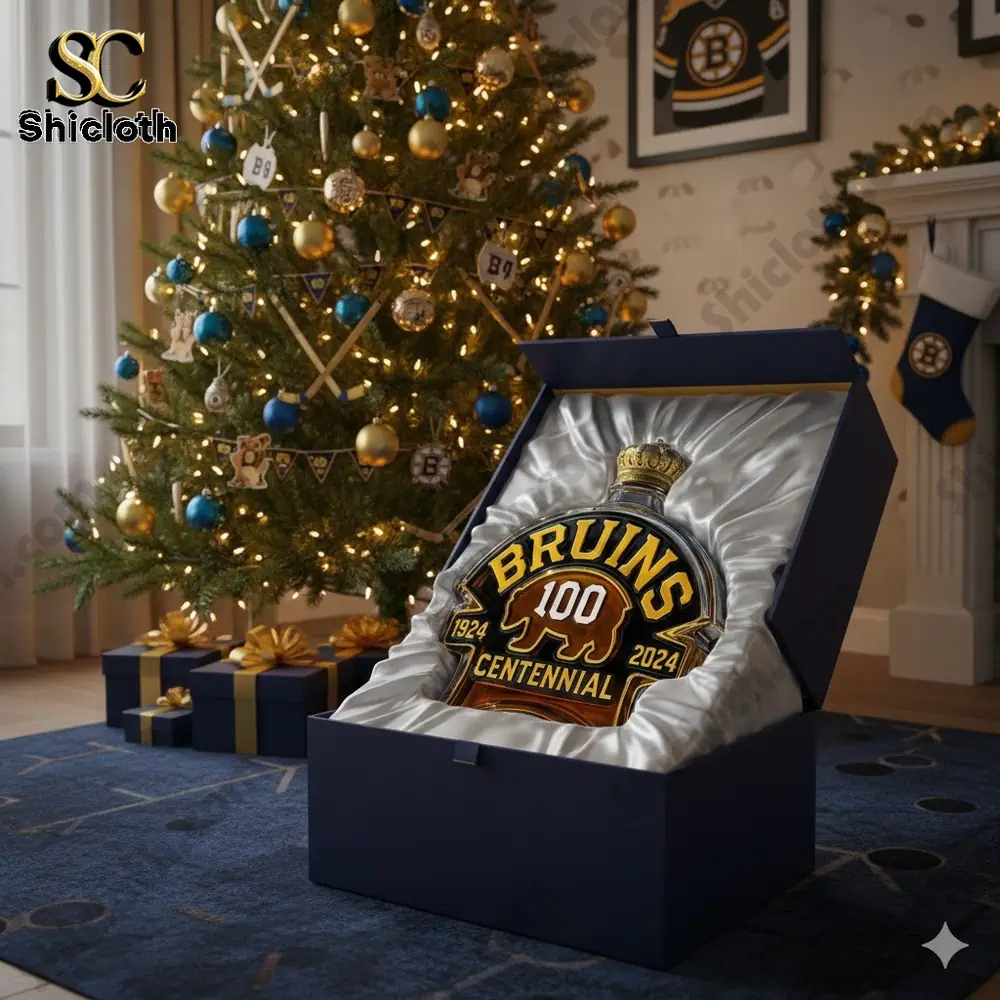 Gift box displaying a Bruins centennial bottle in front of a decorated Christmas tree.