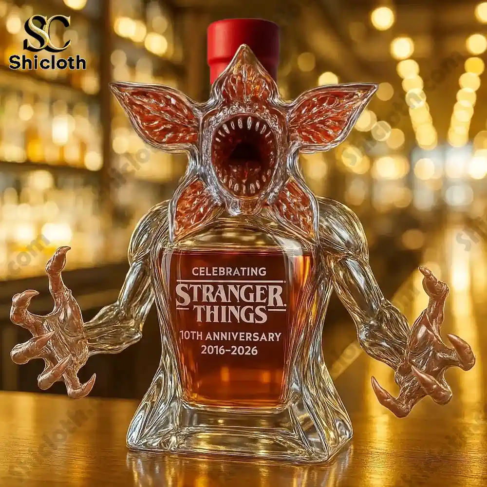 Demogorgon Celebrating Stranger Things' 10th Anniversary Whiskey Bottle Full Box 5 Demogorgon shaped bottle with a red cap displayed on a bar top.