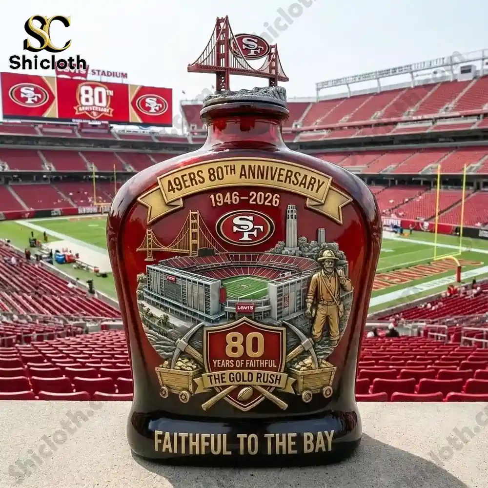 A 49ers 80th Anniversary whiskey bottle featuring the Golden Gate Bridge, stadium, and miner displayed in front of Levi's Stadium.