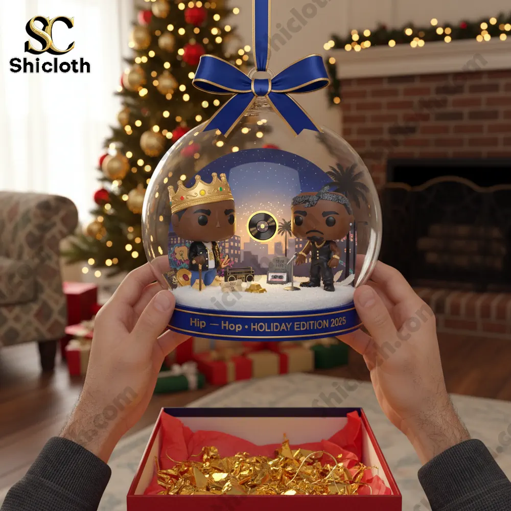 Hands hold a clear ornament featuring two hip hop styled figures inside a snowy scene.