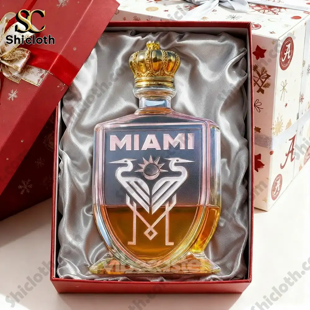 A whiskey bottle with a crown cap, featuring the word "MIAMI" and a distinctive logo with two birds and a sun on a pink and gold bottle.