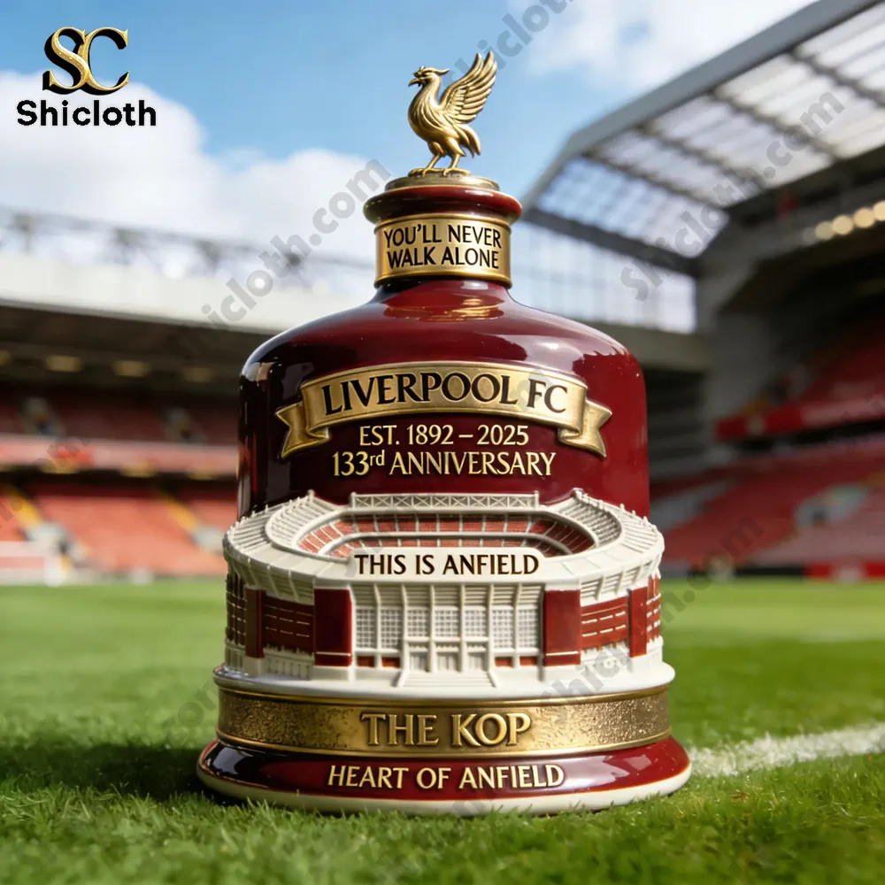Liverpool FC 133rd Anniversary Heritage Collector Bottle displayed at Anfield Stadium with the Kop stand in the background.