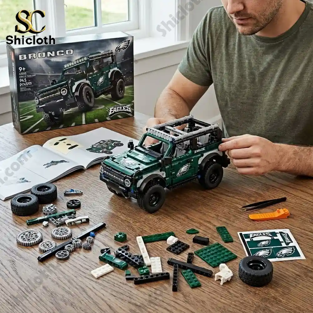 All Teams NFL x Bronco 60th Anniversary Collector Brick Set 13 A person assembling a green Eagles themed brick Bronco model on a table with parts and instructions.