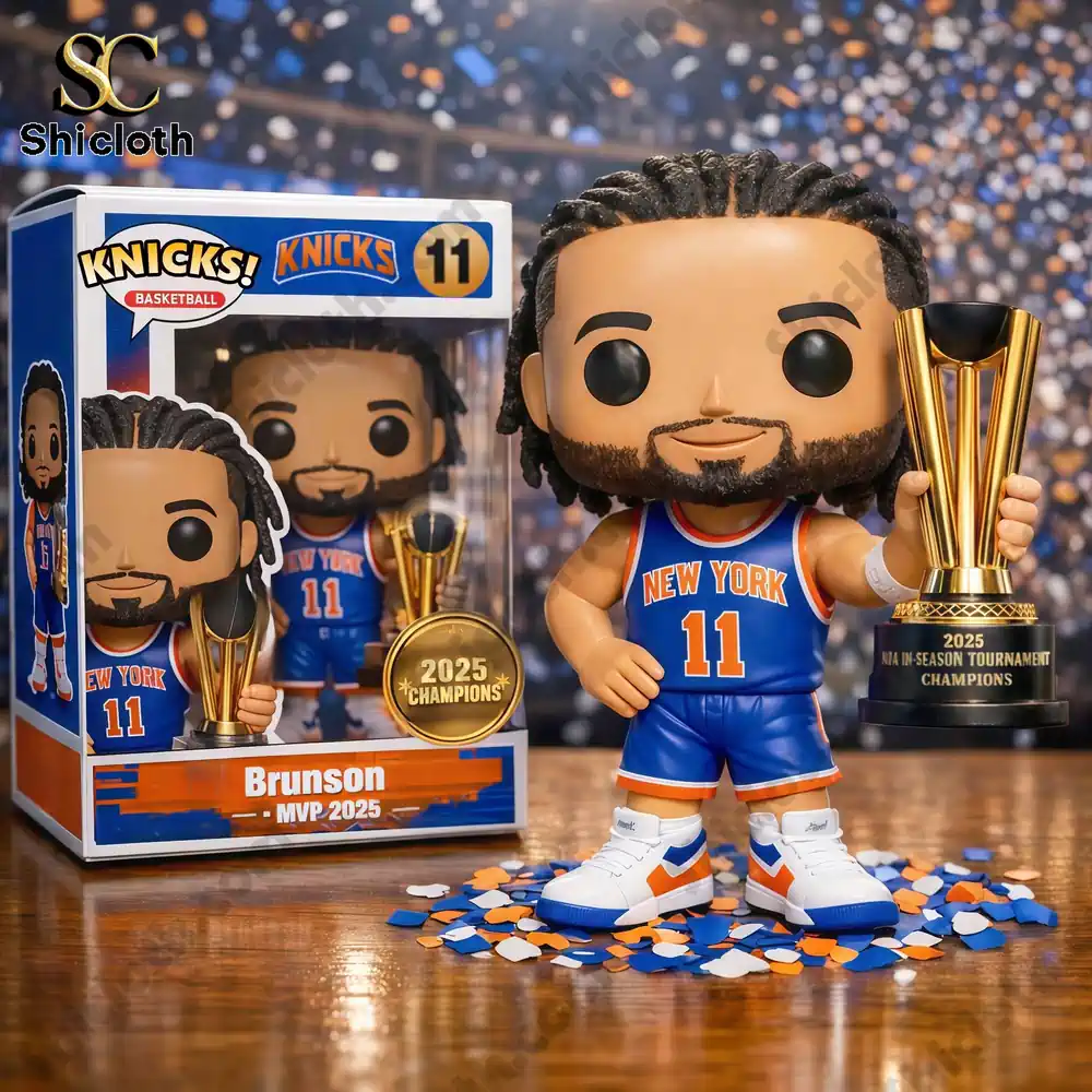 A toy basketball player in a New York jersey holding a trophy beside its box with a crowd background.