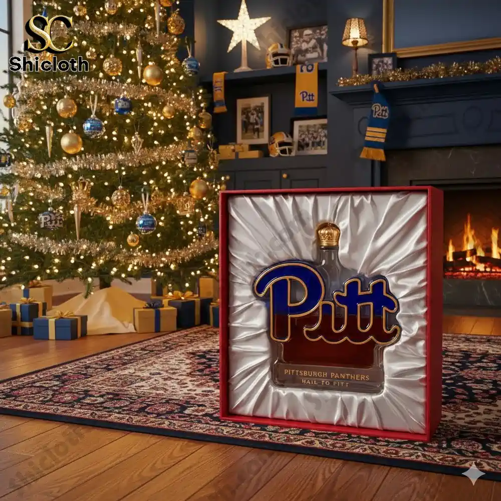 A limited edition Pittsburgh Panthers whiskey bottle in a gift box with a Christmas tree in the background.