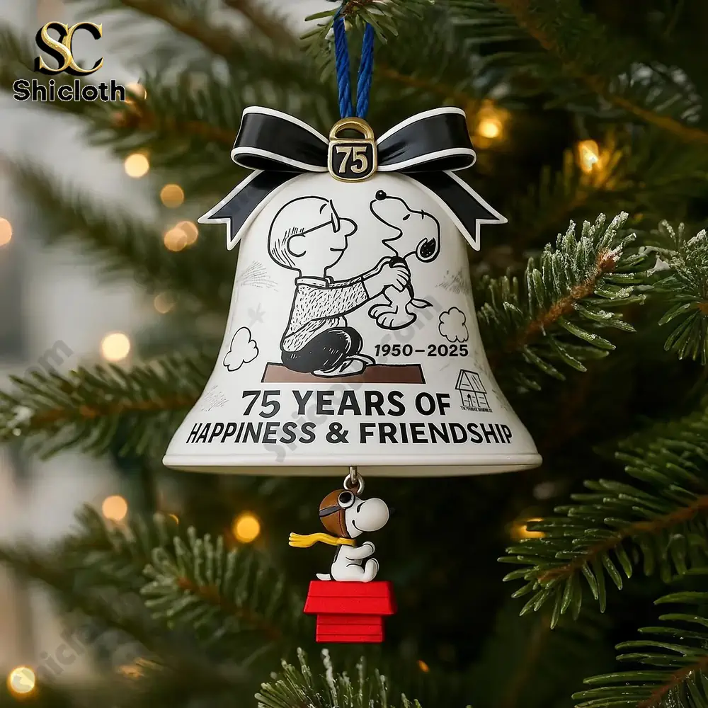 Close view of a Snoopy anniversary bell ornament hanging on a Christmas tree.
