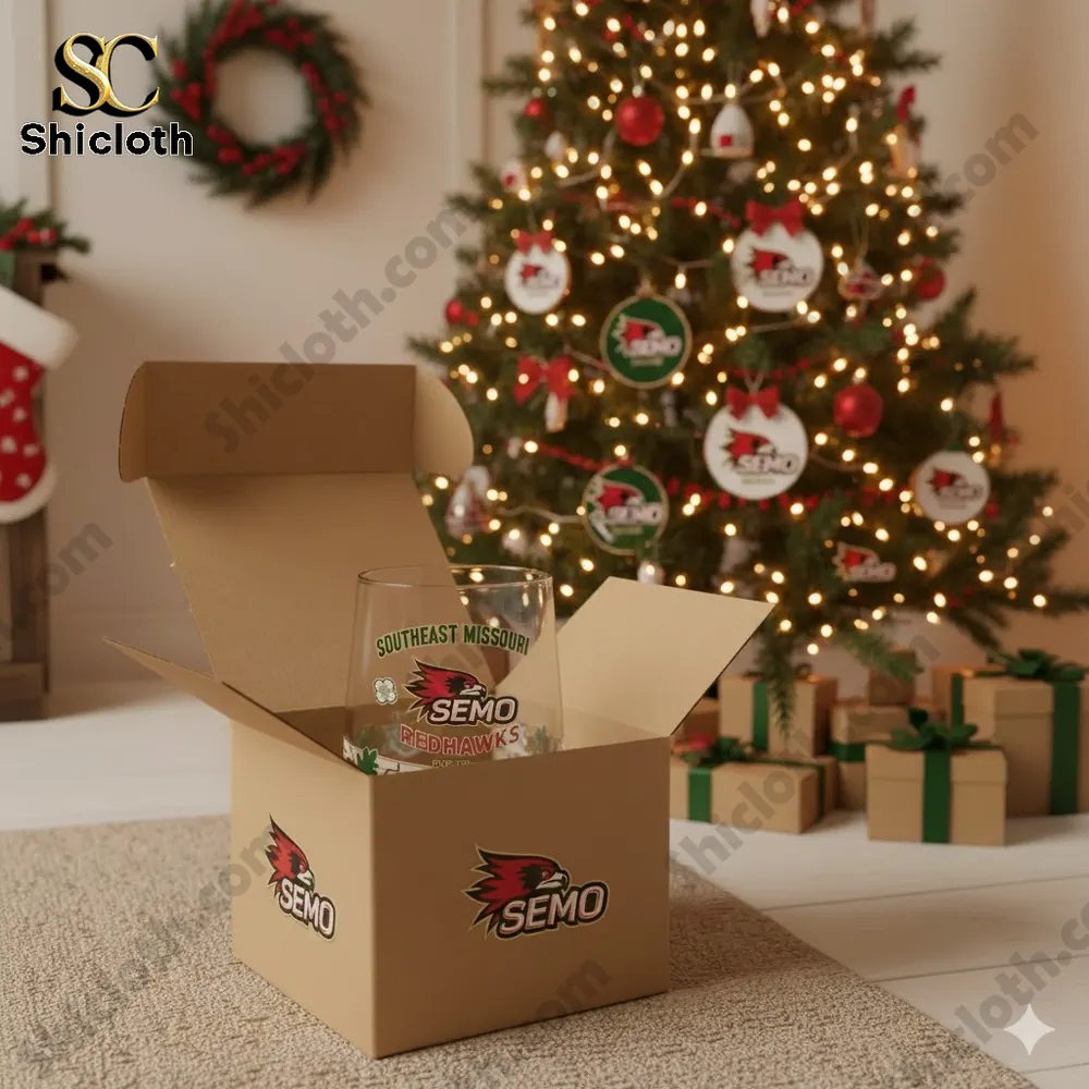 Southeast Missouri State Redhawks glass in a gift box near a Christmas tree with presents.
