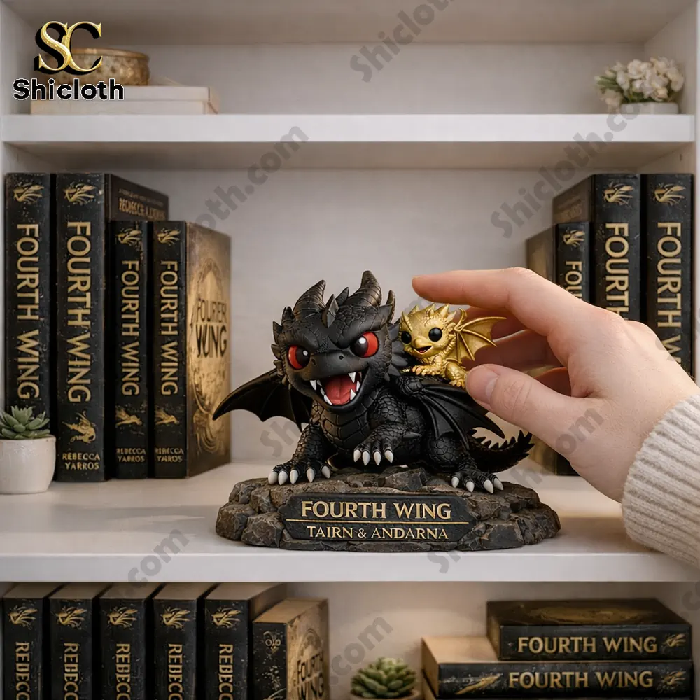 Hand touching a black and gold dragon statue on a bookshelf with Fourth Wing books