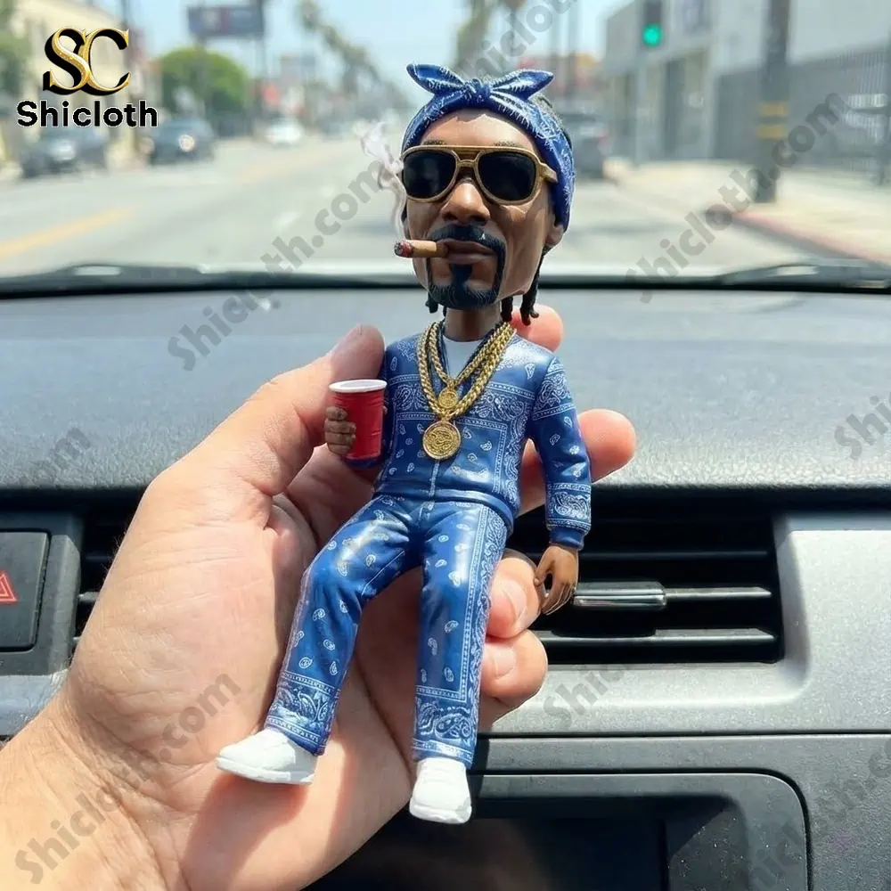 Street style figurine sitting on car dashboard holding a red cup!