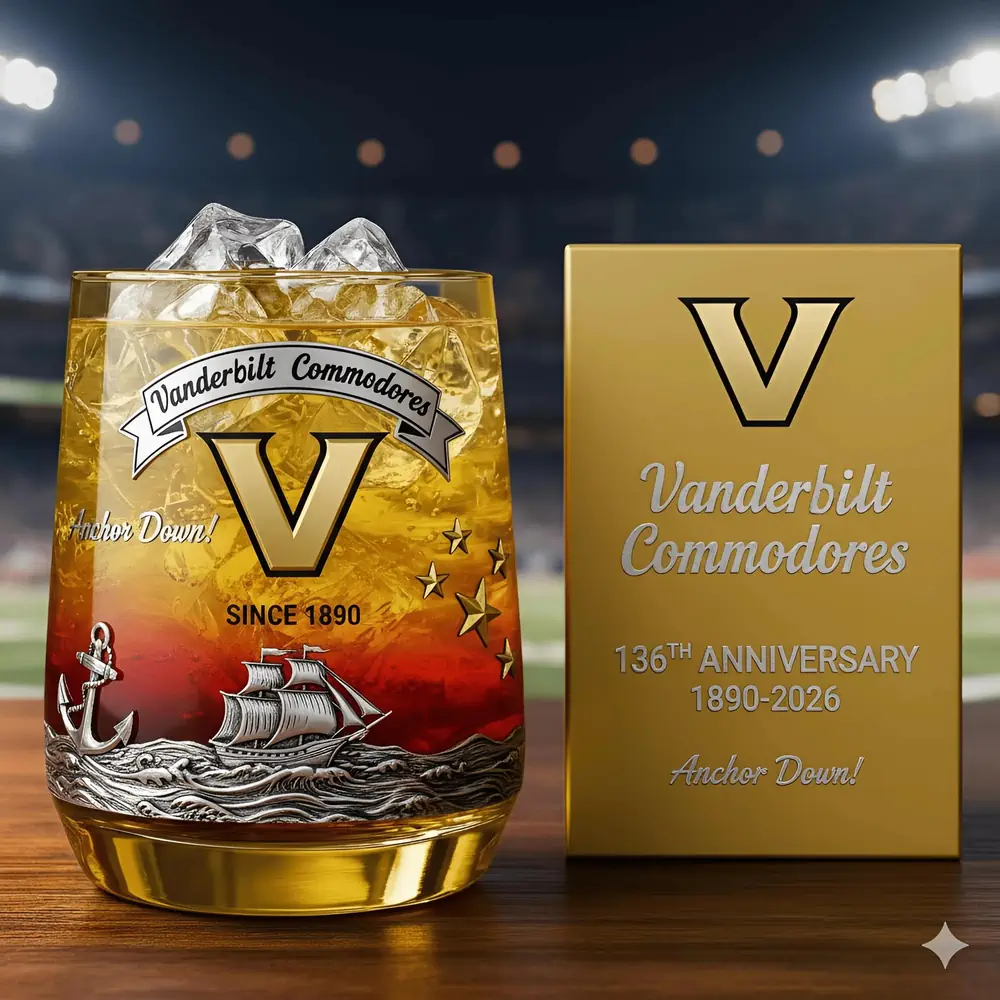 Vanderbilt Commodores football 136th Anniversary Christmas Whiskey Glass 3 A Vanderbilt anniversary glass with ice next to a commemorative box on a table by a stadium field!