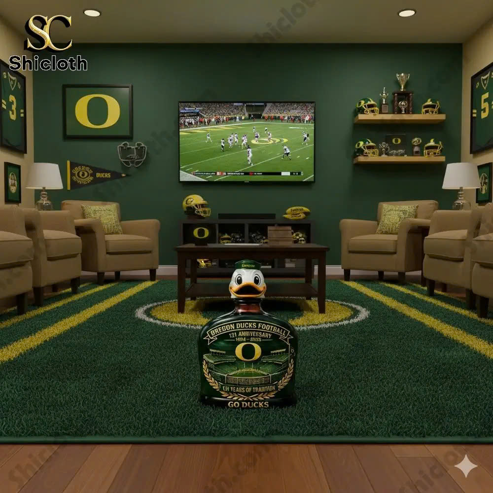 A football-themed room with Oregon Ducks memorabilia, including helmets and trophies, with a TV showing a game.